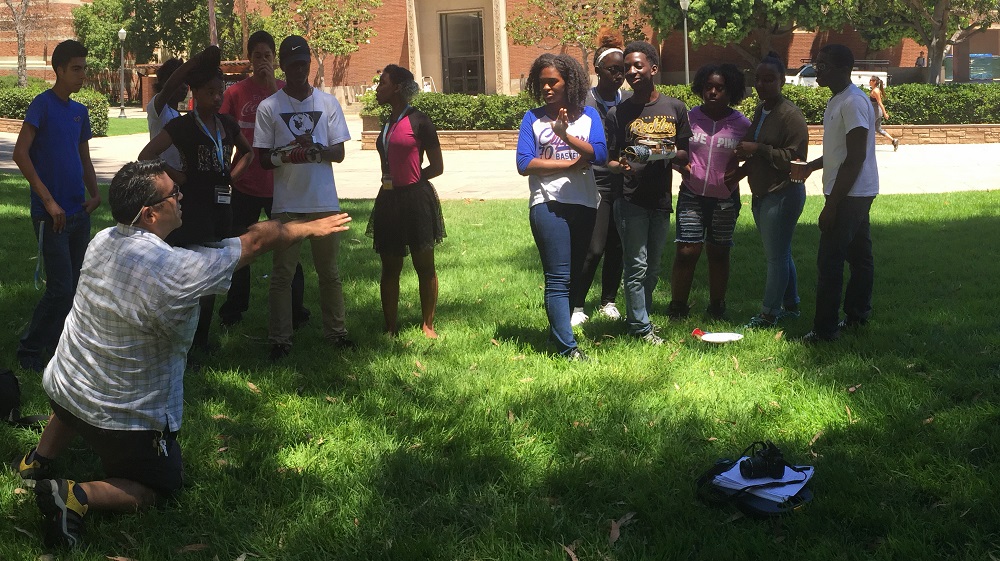 SMASH Academy Participants take part in an outdoor activity on the grass in front of Boelter hall.
